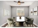 Bright dining room featuring an oval table, stylish chairs, modern art, and natural light at 36076 N Vidlak Dr, San Tan Valley, AZ 85143