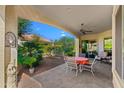 Covered patio with a table and chairs, perfect for outdoor dining and relaxation, overlooking a lush backyard at 4138 E Indigo St, Gilbert, AZ 85298