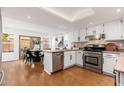 Bright kitchen featuring white cabinets, stainless steel appliances, and hardwood floors at 4151 E Mercer Ln, Phoenix, AZ 85028