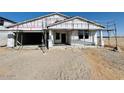 New home construction in progress with visible framework, including a two-car garage and covered entryway at 47248 W Cansados Rd, Maricopa, AZ 85139