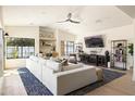 Cozy living room with white sofa, TV, modern fan, and large windows offering plenty of natural light at 5137 E Flower St, Phoenix, AZ 85018