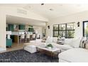 Bright living room featuring a comfortable white sectional sofa, stylish rug, and views into the kitchen at 5137 E Flower St, Phoenix, AZ 85018