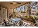 Relaxing covered patio with a ceiling fan, outdoor seating, lush greenery, and a pergola view at 5230 E Brown Rd # C117, Mesa, AZ 85205