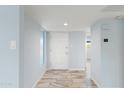 Clean, bright hallway with modern tile flooring leads to entryway and other living areas at 7819 E Coolidge St, Scottsdale, AZ 85251