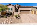 Charming home featuring desert landscaping, stone accents, a paver driveway, and a two-car garage at 8304 E Inca St, Mesa, AZ 85207