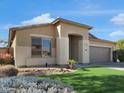 Charming single-story stucco home with a well-kept lawn, desert landscaping, and a two-car garage at 9477 W Tonopah Dr, Peoria, AZ 85382