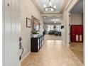 Inviting home foyer with tile flooring, a decorative chandelier, and views into the spacious living area at 10322 E Topaz Ave, Mesa, AZ 85212