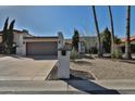 Charming single-story home featuring a two-car garage and desert landscaping at 10421 E Silvertree Dr, Sun Lakes, AZ 85248