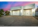 Three car garage with desert landscaping and a lovely pink and blue dusk sky at 11343 E Appaloosa Pl, Scottsdale, AZ 85259