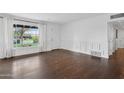 Bright living room with hardwood floors, large window, and white trim at 1414 E Vermont Ave, Phoenix, AZ 85014