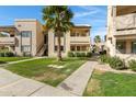 Well-maintained apartment complex exterior with lush green landscaping, sidewalks, and a blue sky at 145 N 74Th St # 121, Mesa, AZ 85207