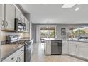 Modern kitchen with stainless steel appliances, white cabinets and natural light at 15116 W Carbine Way, Sun City West, AZ 85375