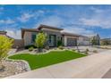 Charming home with a modern elevation, manicured lawn, stone pathway, and spacious two-car garage at 1557 E Flower St, Gilbert, AZ 85298