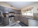 Modern kitchen with stainless steel appliances, gray cabinets, and tile backsplash at 16409 S 46Th St, Phoenix, AZ 85048