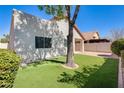 Private backyard with lush green artificial turf, mature tree, and block wall fencing at 1713 E Morelos St, Chandler, AZ 85225