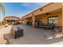 Spacious covered patio area with comfortable seating and an outdoor tiki bar at 17470 W Gelding Dr, Surprise, AZ 85388