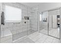 Bright bathroom showcasing a glass-enclosed shower with modern fixtures and marble tile at 17470 W Gelding Dr, Surprise, AZ 85388
