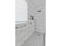 Beautiful bathroom with marble tile, a rainfall showerhead, and a frameless glass enclosure at 17470 W Gelding Dr, Surprise, AZ 85388
