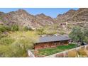 Rear view of hillside home with covered patio overlooking the well maintained backyard and scenic mountains at 1844 E Cinnabar Ave, Phoenix, AZ 85020