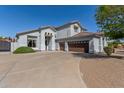 Spacious home featuring a wide driveway leading to a three-car garage at 18468 N 63Rd Dr, Glendale, AZ 85308