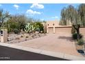 Desert landscaping accents this home's exterior and long driveway at 18944 E Amethyst Dr, Rio Verde, AZ 85263