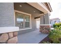 Inviting front porch highlighted by stone-accented pillars and a clear view of the home's entry and garage at 19975 W Glenrosa Ave, Litchfield Park, AZ 85340