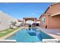 A backyard featuring a sparkling pool, gazebo, and lounge chairs, ideal for outdoor relaxation at 19990 W Turney Ave, Litchfield Park, AZ 85340