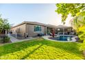 Beautiful backyard featuring a pool, lush green lawn, and covered patio area ideal for outdoor entertaining at 20138 E Estrella Rd, Queen Creek, AZ 85142