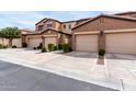 Exterior of townhomes with attached garages, desert landscaping, and wide sidewalks at 250 W Queen Creek Rd # 240, Chandler, AZ 85248