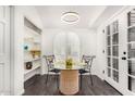 Cozy breakfast nook with a glass table, French doors, and a built-in shelving unit at 2824 N 42Nd Way, Phoenix, AZ 85008