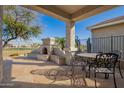 Charming covered back patio with outdoor fireplace and cozy seating area at 30153 N Gecko Trl, San Tan Valley, AZ 85143