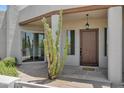 Inviting front entrance with a wood door, desert landscaping, and a hanging lantern under the porch at 30600 N Pima Rd # 24, Scottsdale, AZ 85266