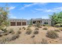 Gorgeous Southwestern house with a three-car garage, showcasing the natural desert landscaping in the front yard at 30600 N Pima Rd # 24, Scottsdale, AZ 85266