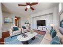 Bright living room featuring a ceiling fan, hardwood floors, and a decorative rug and furniture at 34705 N 26Th Ave, Phoenix, AZ 85086