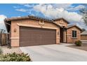 Single-story home featuring a two-car garage and low-maintenance desert landscaping at 38062 W San Capistrano Ave, Maricopa, AZ 85138