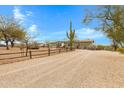 View of the green single-story ranch-style home with a gravel driveway and desert landscaping at 38413 N 16Th St, Phoenix, AZ 85086