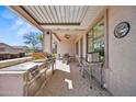 View of covered patio featuring a grill, stainless steel countertop, and outdoor dining area at 43851 W Griffis Dr, Maricopa, AZ 85138