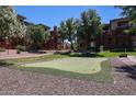 Putting green surrounded by manicured lawns and trees at this condominium complex at 5401 E Van Buren St # 2053, Phoenix, AZ 85008