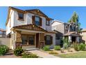Charming two-story home featuring a stucco exterior, brown shutters, and a well-maintained landscaped front yard at 5828 E Hoover Ave, Mesa, AZ 85206