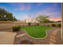 Expansive backyard featuring lush lawn, manicured landscaping, and beautiful sunset views at 6309 E Crocus Dr, Scottsdale, AZ 85254