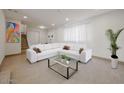 Bright living room with a large white sectional sofa and neutral tile flooring at 8442 E Chaparral Rd, Scottsdale, AZ 85250