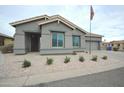 Inviting single-story home featuring a two car garage, desert landscaping, and an American flag waving in the breeze at 888 E Sheffield Ave, Chandler, AZ 85225