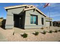 Inviting single-story home featuring a two car garage, desert landscaping, and an American flag waving in the breeze at 888 E Sheffield Ave, Chandler, AZ 85225