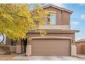 Two-story home with a two-car brown garage door and well-manicured landscaping in a modern style at 900 W Broadway Ave # 66, Apache Junction, AZ 85120