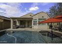 A private backyard featuring a pool and covered patio with comfortable seating, perfect for outdoor entertaining at 9149 E Auburn St, Mesa, AZ 85207