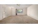 Neutral living room features a large window, carpet, and a ceiling fan at 9614 W Pleasant Valley Rd, Sun City, AZ 85351