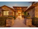 Covered entryway featuring stone pillars, potted plants, and decorative metal gate at 15751 W Linksview Dr, Surprise, AZ 85374