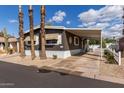 Home exterior showcases desert landscaping, covered parking, palm trees, and a cozy, welcoming facade at 201 S Greenfield Rd # 152, Mesa, AZ 85206