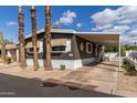 Home exterior showcases desert landscaping, covered parking, palm trees, and a cozy, welcoming facade at 201 S Greenfield Rd # 152, Mesa, AZ 85206