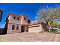 A beautiful two-story home featuring a brick driveway and an attached garage at 35210 N 34Th Ln, Phoenix, AZ 85086